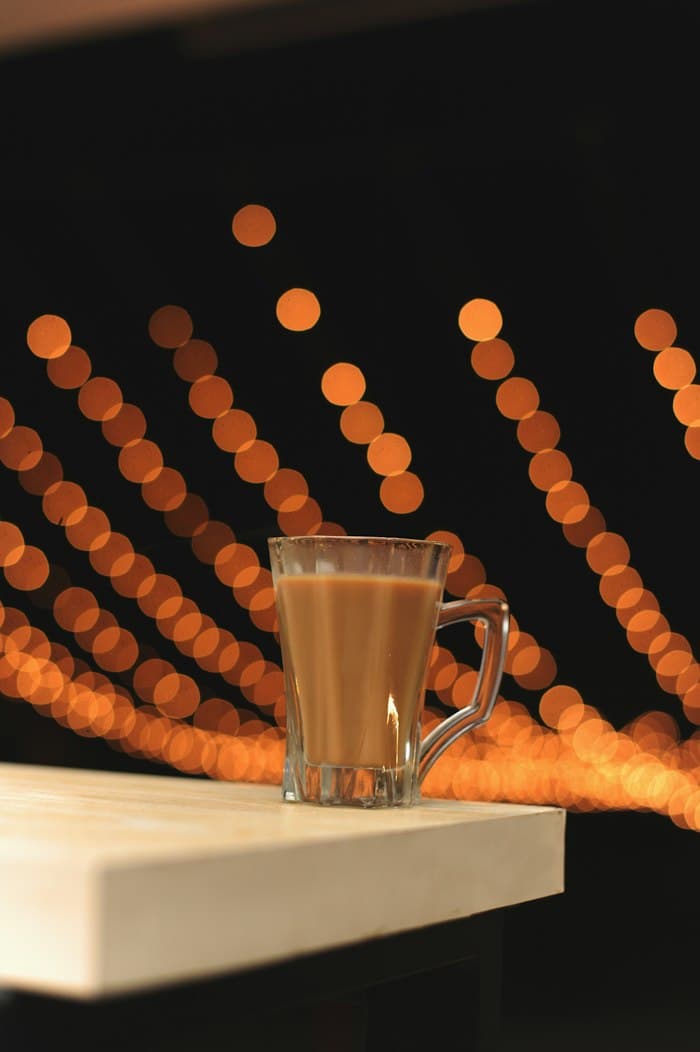 A glass of chai against warm evening lights
