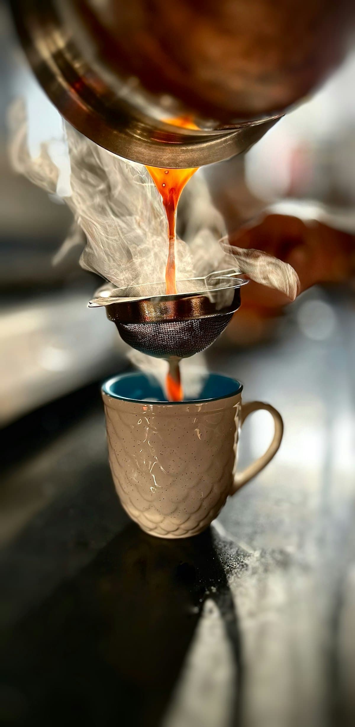 Steaming chai being strained into a cup
